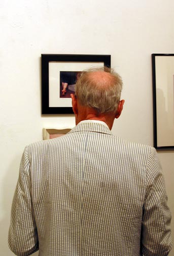 A gallery visitor viewing a framed photograph on display at To the Nth Degree, Touchstone Gallery, 2002