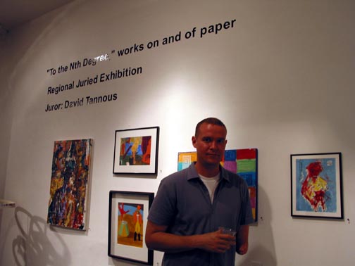 Matt Sesow standing beneath the To the Nth Degree exhibition wall text at Touchstone Gallery, 2002
