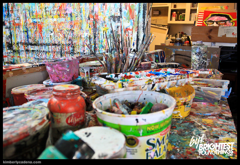 Paint jars and brushes on a paint-covered table