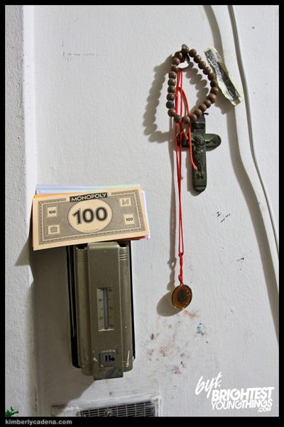 A light switch with a rosary and play money