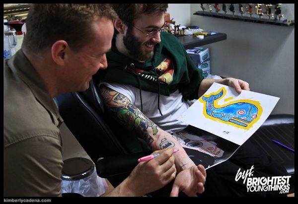 Matt with a man getting a tattoo, and the whale drawing