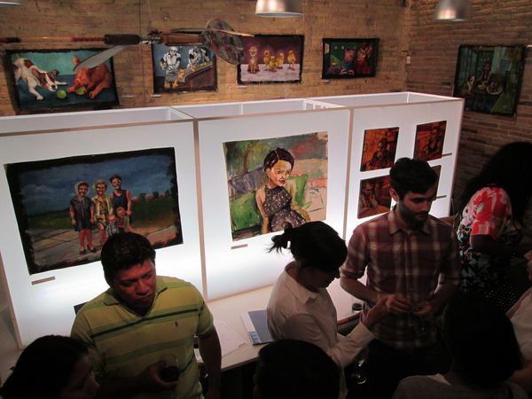 A crowd at the opening in front of Dana Ellyn's paintings on the white panels