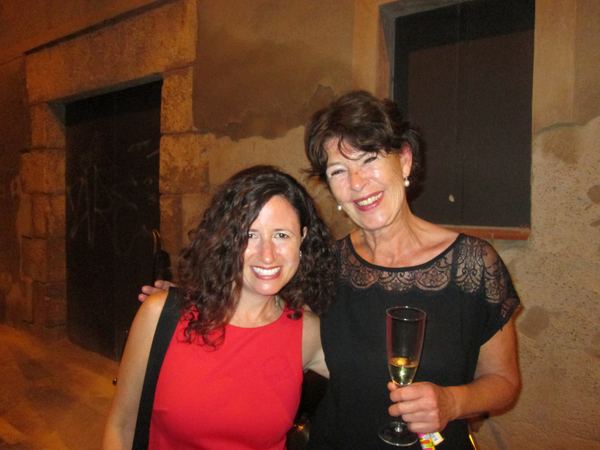 Dana Ellyn with a guest holding a glass outside the gallery at night