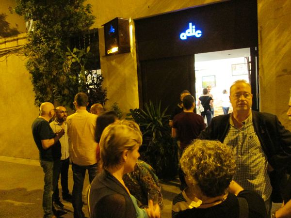 A crowd outside the lit Flash Gallery entrance at night
