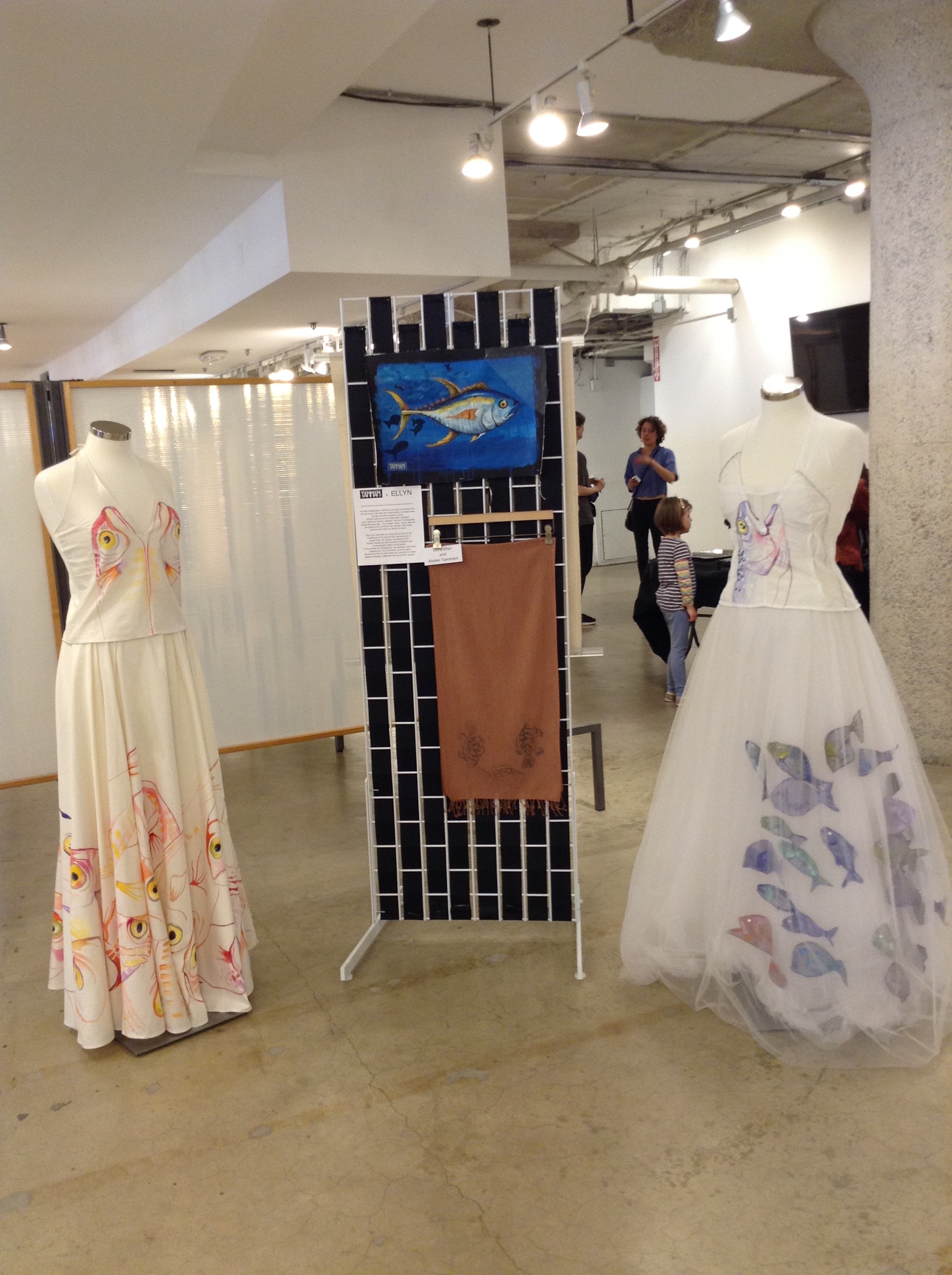 Two Bycatch, By Hand dresses on mannequins at Moda 360, with Ellyn’s yellowfin tuna painting and a block-printed scarf between them