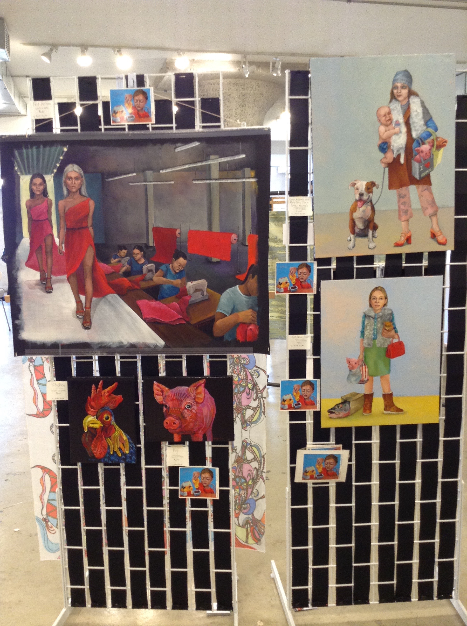 Display of Dana Ellyn paintings at Moda 360, including Fast Fashion, a rooster, a pig and two figures with animals