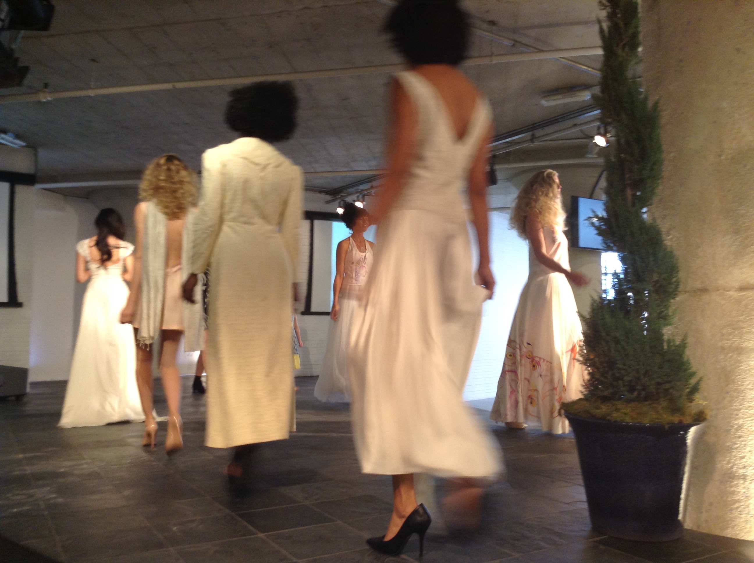 Models in white and cream walking the Moda 360 runway, including both Bycatch, By Hand dresses