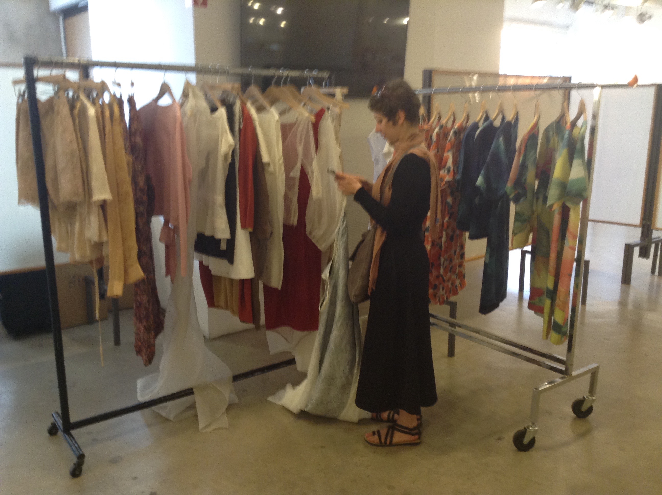 Lucy Tammam looking through racks of clothing at Moda 360