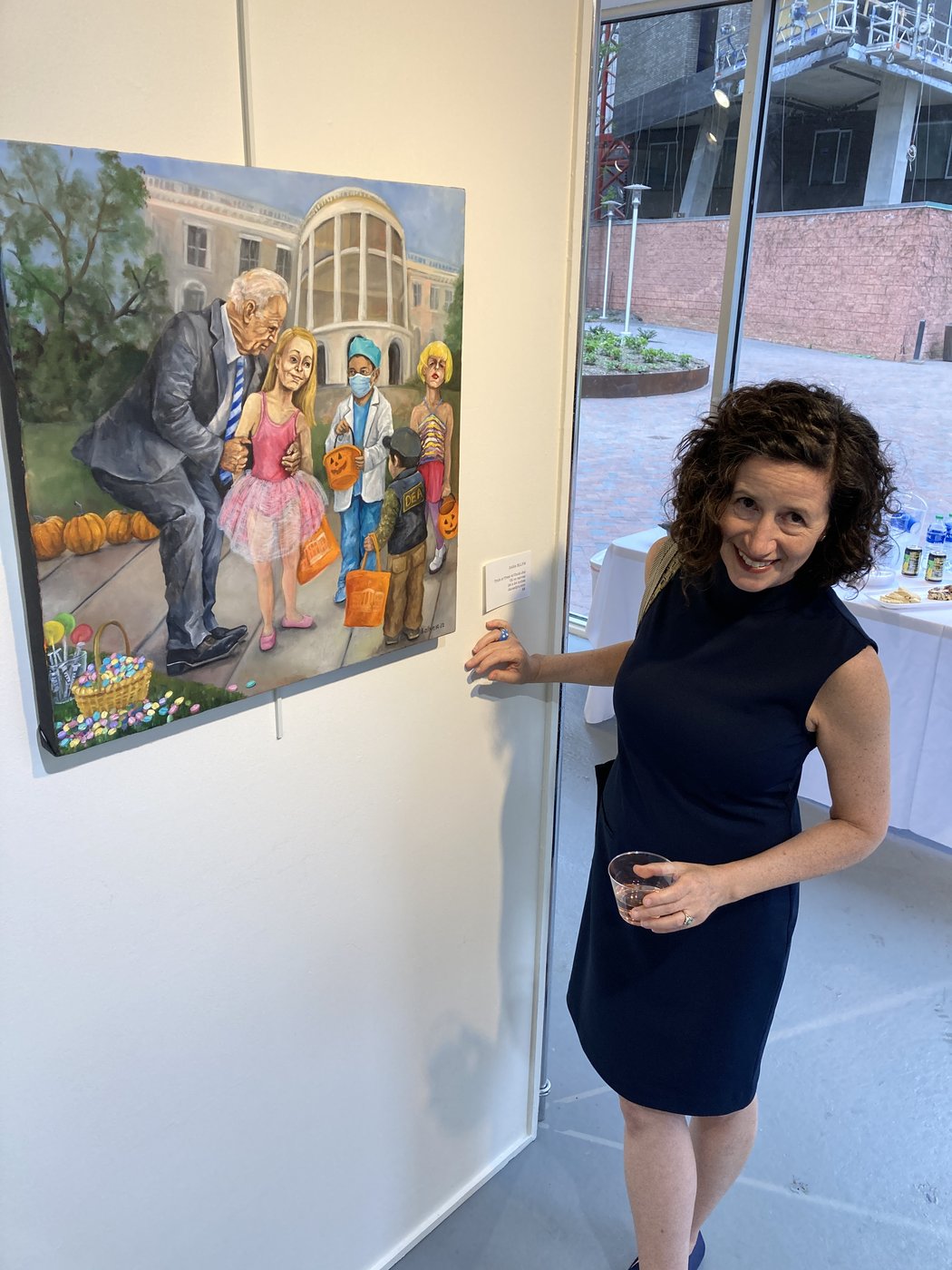 Dana Ellyn beside her painting Trick or Treat (with Uncle Joe) at the c'est l'art reception at Gallery B